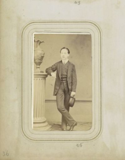 Portrait of A.J. Bakker in a three-piece suit holding a hat