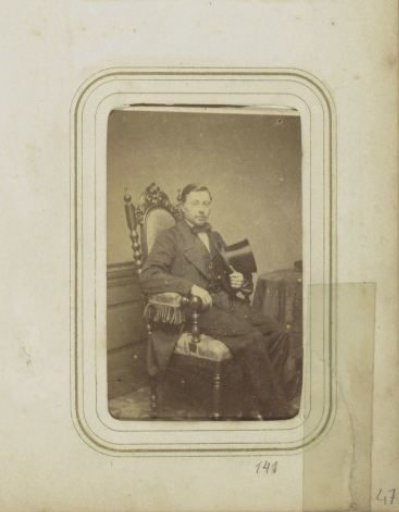 Portrait of a man with a tall hat in his hand