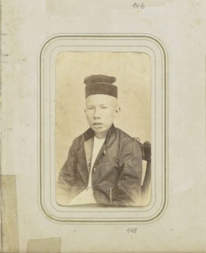 Portrait of a young man in a coat with a head covering