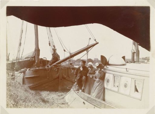 Man and two women on a ship at a quay in the North Holland Canal
