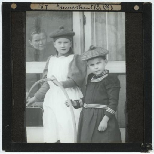 Unknown woman behind a window, and two children with a hoop