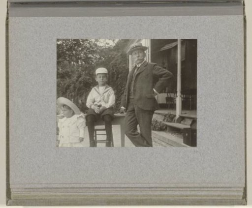 J.B. Aug. Kessler with two of his children beside him in front of the veranda, case at bottom right