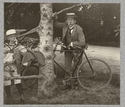 J.B. Aug. Kessler leaning on his bicycle, with his son