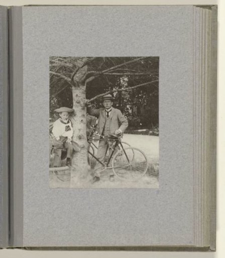 J.B. Aug. Kessler during a bicycle ride with his young son in a sailor's outfit in the tree