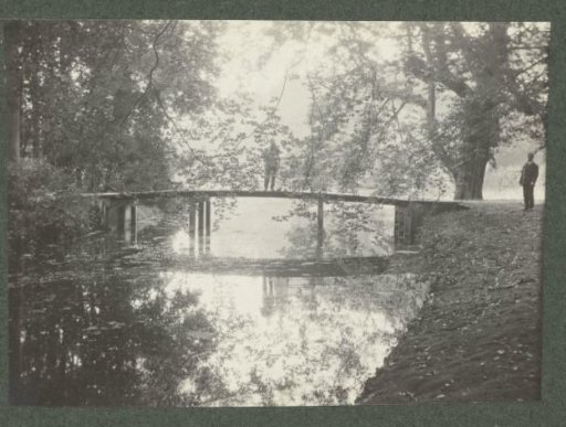 Two people posing by a bridge over water at De Paauw estate