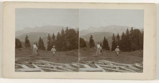 Mrs. Kessler-de Lange and two children playing in a field at Garmisch