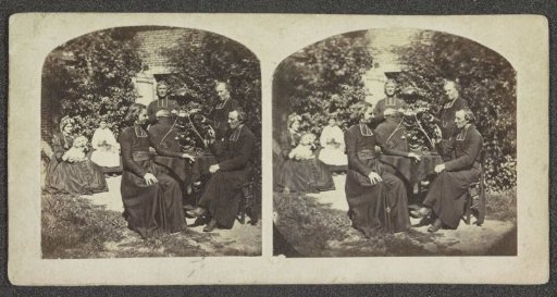 Three Clergymen Standing and Sitting Around a Table in a Garden, with Two Women Holding Dogs on Their Knees in the Background