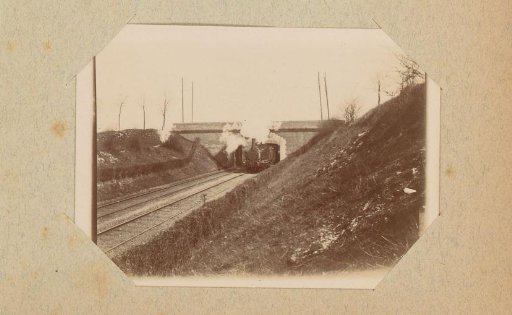 Steam train passing under a bridge