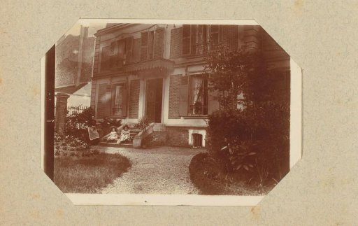 Two girls and a woman in front of a house