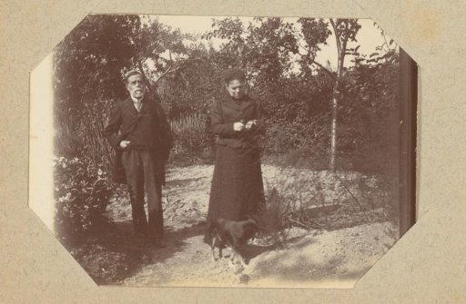 Portrait of an old man and woman with a dog in a garden