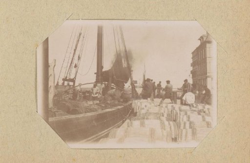 Barrels on the quay beside a ship