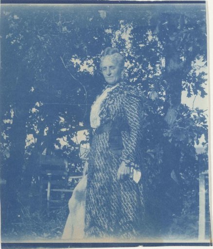Portrait of an unknown old woman, standing in a garden or park