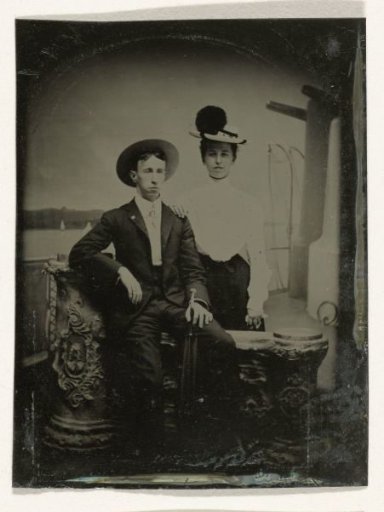 Portrait of a man and a woman, one standing and one sitting, in front of a painted backdrop (ship deck)