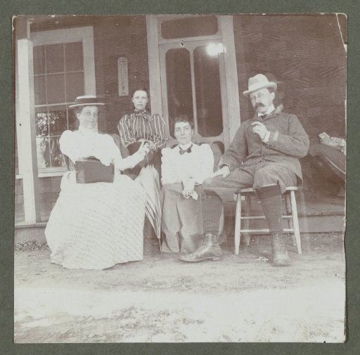 Group portrait of three women and a man in front of a house, United States