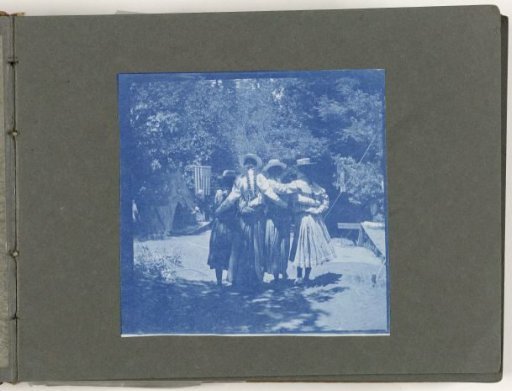 Four girls with arms around each other seen from the back, United States