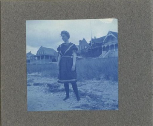Woman posing in front of wooden houses, United States
