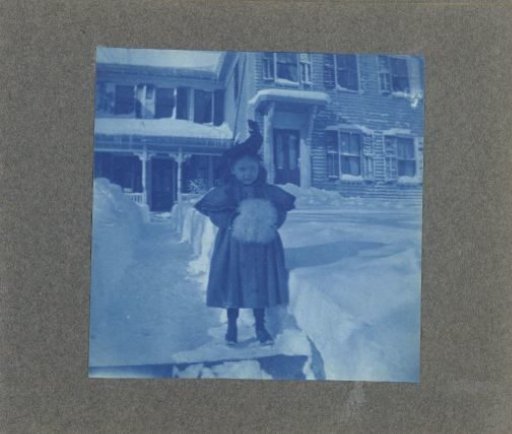 Girl in the snow, hands in a muff, United States
