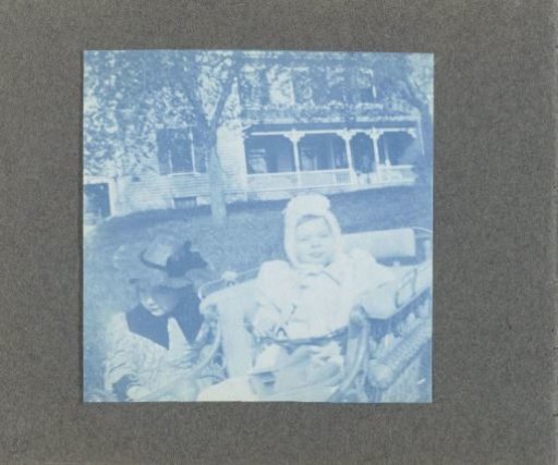 Two children before a wooden house, United States