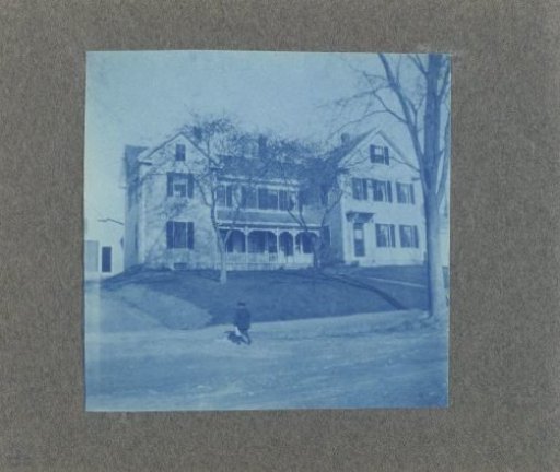 Child walking before a wooden house, United States