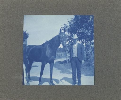 Man holding a horse by the reins, United States