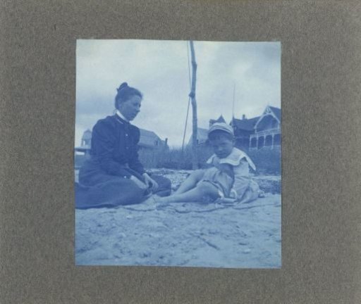 Woman with a child sitting on the beach, United States