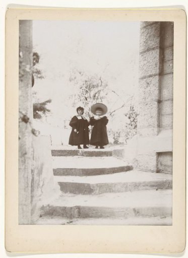 Two children and a woman at a staircase