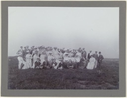 Group portrait of approximately 50 men and women in a landscape