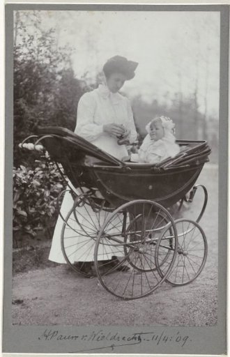 Thelma Pauw van Wieldrecht as a toddler in a pram with a nanny beside her