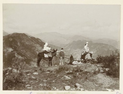 Three people during a picnic in a mountainous landscape