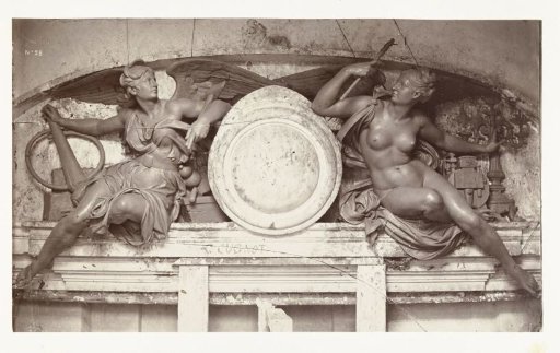 Two statues of female angels on either side of a medallion, situated above a doorway