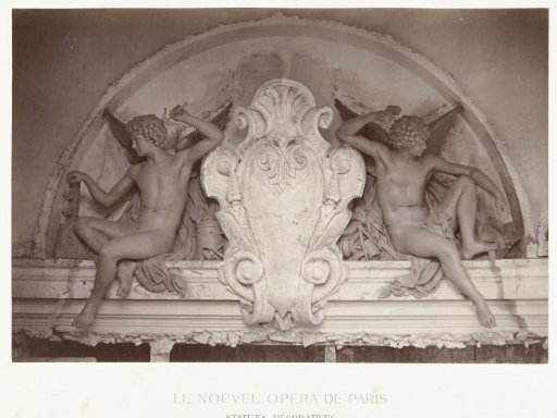 Two statues of male angels holding hammers, seated on either side of a medallion, situated above a doorway