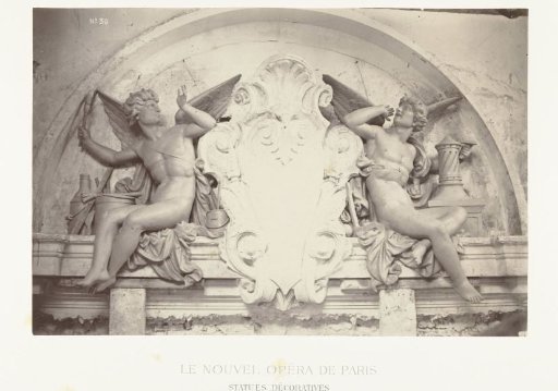 Two statues of male angels holding brushes, seated on either side of a medallion, situated above a doorway
