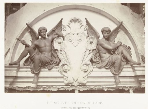 Two bronze statues of male angels holding wheels and mallets, seated on either side of a medallion, situated above a doorway