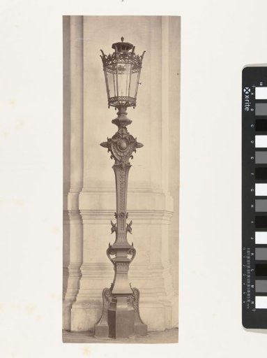 Lantern with six-paned windows in a bronze frame, resting on a bronze stand