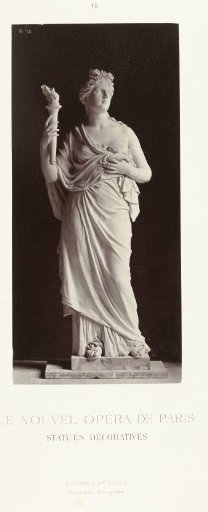Marble statue of a woman in a robe with a bare breast, holding a torch in her hand.