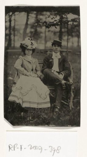 Portrait of a man and a woman sitting on a bench in a forest or park-like setting