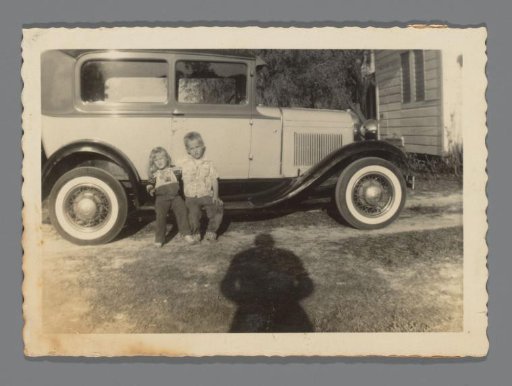Ford Model A Tudor Sedan with two children in front of it