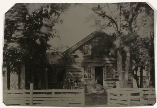 View of a Wooden House, with Five Persons and a Dog (?) in Front