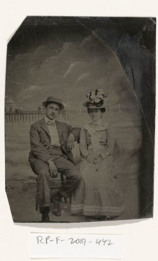 Portrait of a Man and Woman Seated Before a Painted Backdrop (Beach, Sea, and Pier)