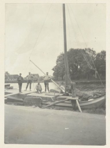Four men on board a flat-bottomed boat at the waterfront