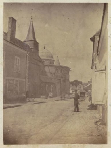 Street view with a church tower and dome in Neuvy-Saint-Sépulchre