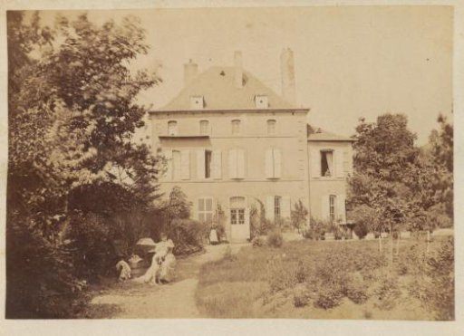 Woman with baby sitting in the garden of a country house in France