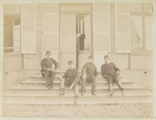 Group portrait of five French soldiers posing on the steps in front of a house