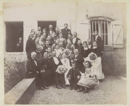 Group portrait of a bride and groom with guests in France