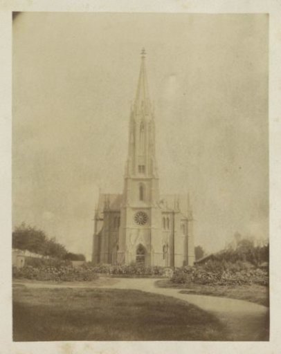 Exterior of a church with a slender tower, probably in France