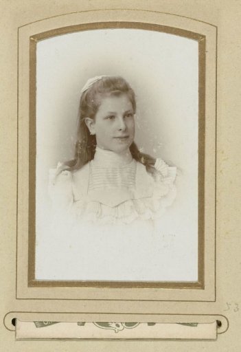 Portrait of a Girl in a White Dress with a Bow in Her Hair
