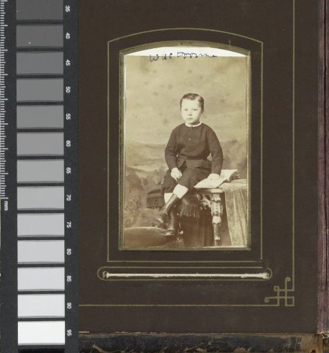 Portrait of a boy from the Doorman family, sitting on a table with a book