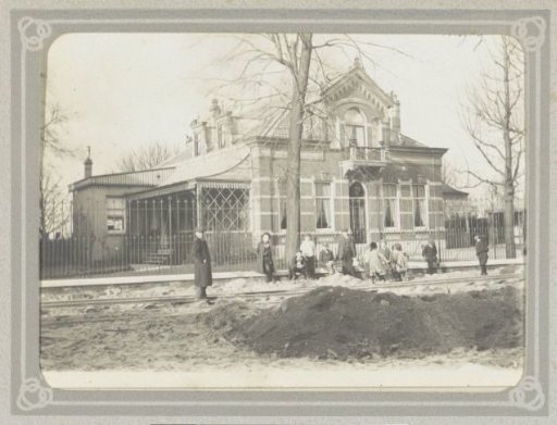 Adults and children near railway tracks in front of a house on the Bergweg in Rotterdam
