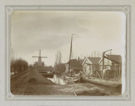 Boatmen on a canal in Overschie, with the paltrokhoutzaagmolen de Adelaar in the background