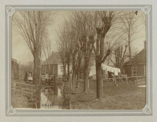 Women, children, trees, and drying laundry by a ditch in Uitwellingerga